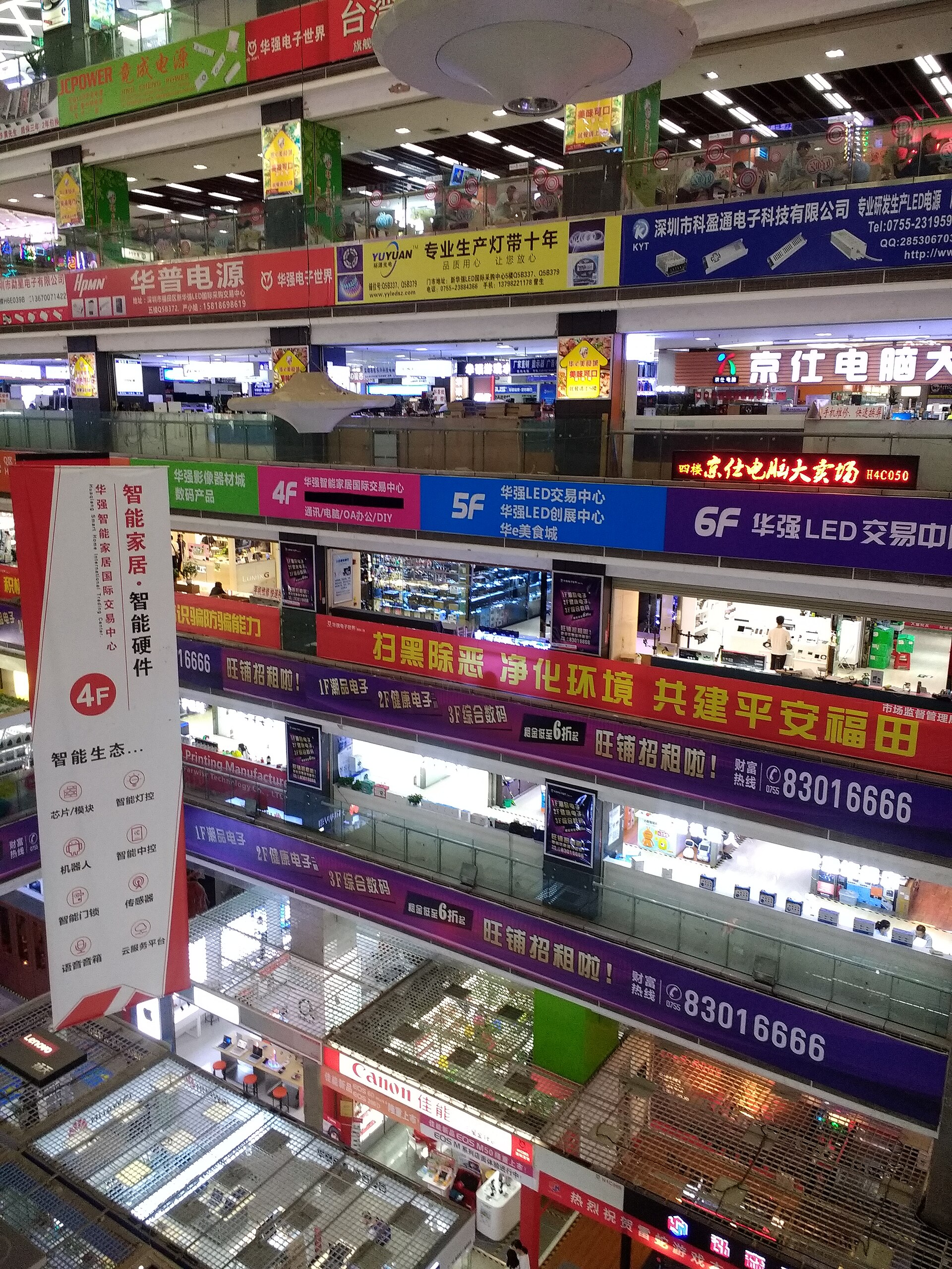 Floors of electronics stalls in a Huaqiangbei market building in Shenzhen, lit signs on every level